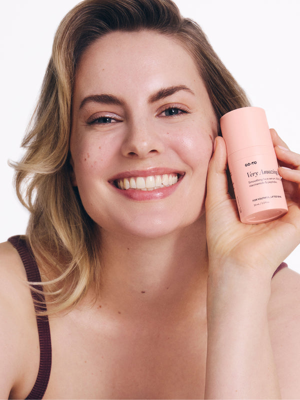 A peach-colored tube of Go-To Very Mattifying Primer standing upright against a soft, neutral background.
