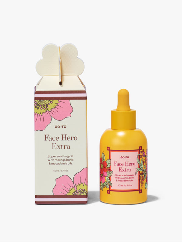 Go-To Skincare Face Hero Extra in a yellow floral dropper bottle beside its matching floral box on a white background